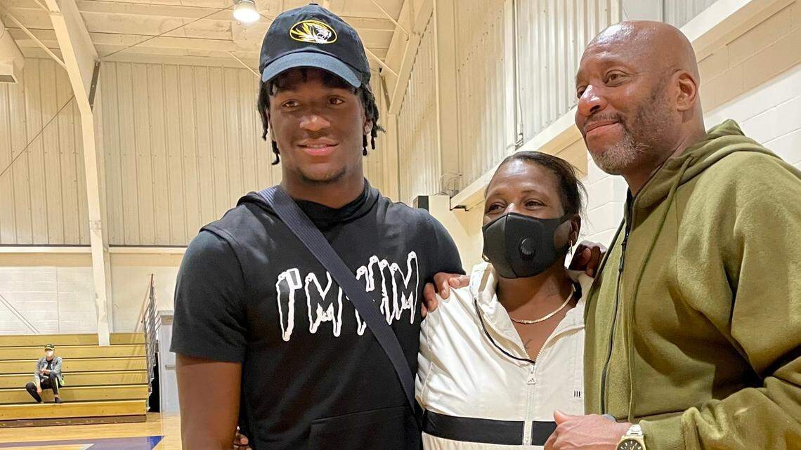 Newly committed to the Mizzou Tigers (check out the hat), Luther Burden, left, with parents Gaye Union and Luther Burden Jr., is set to play his next-level football in Columbia next season.