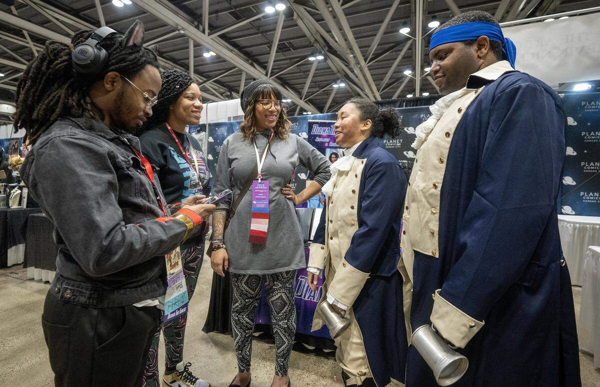 Cosplayers from left, Daniel Alexander (Shadow the Hedgehog), Tiphani Dixon, and Tamarah Dixon of Pros and Cons Cosplay, all of Kansas City, talk with Hamilton cosplayers Jasmine Brower as Lafayette of Joplin, Missouri, and Rafael Richards as Hercules Mulligan of St. Louis during Sunday's festivities at Planet Comicon Kansas City. 