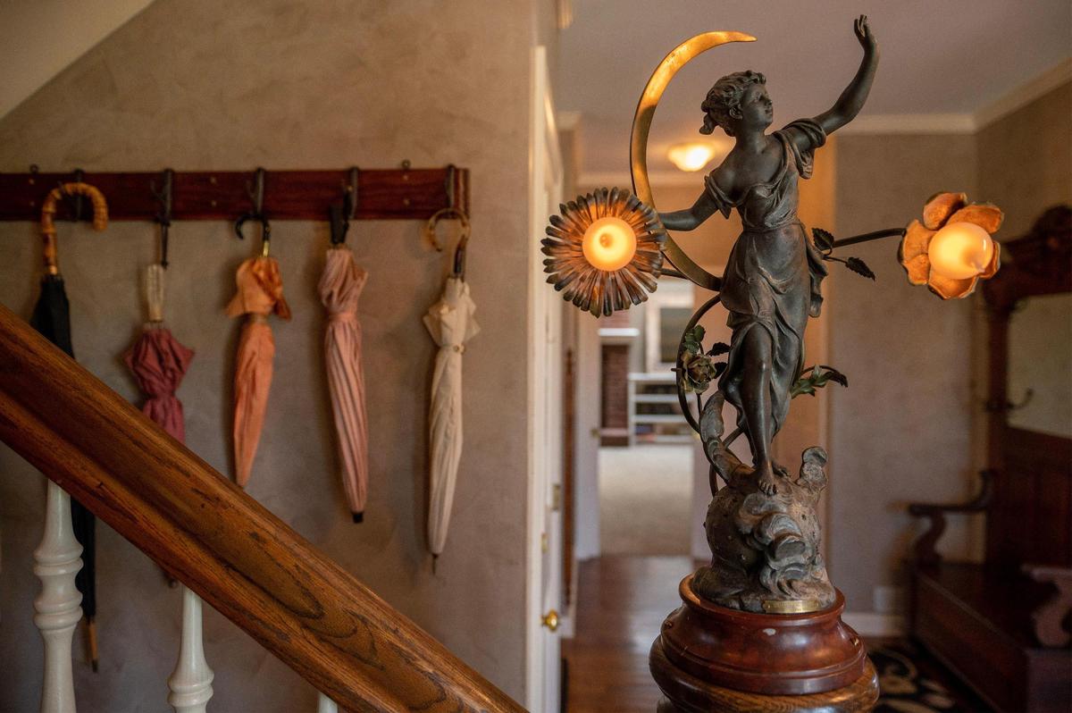 A statue titled “Clair de Lune” is seen on a wooden staircase at a Victorian-style house in Bonner Springs that owner Judy Vickers once ran as a bed and breakfast and enjoyed collecting antique furniture to display around the house.
