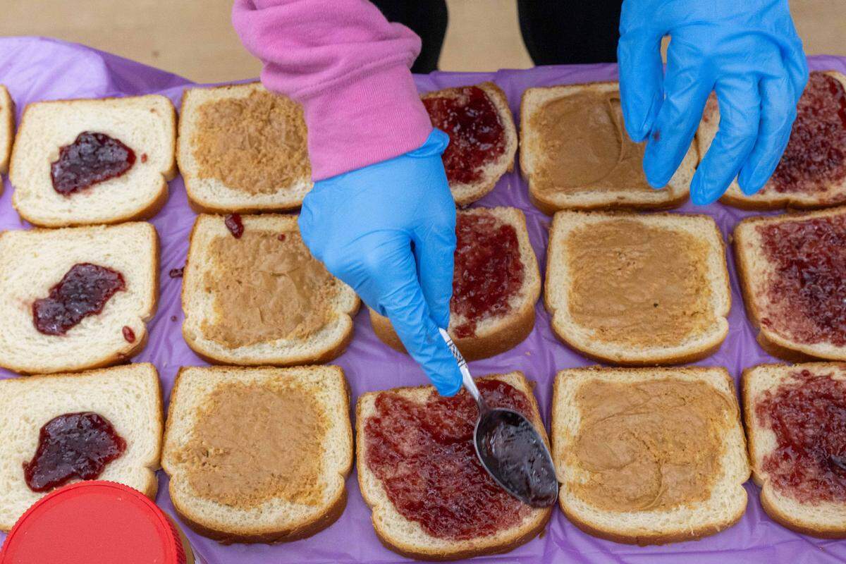 Volunteers made hundreds of peanut butter and jelly sandwiches at Cleaver Family YMCA in Kansas City on Monday, January 19, 2026 to celebrate Martin Luther King Jr. Day. The sandwiches were included in a care package that includes food, sanitary items, and a bed mat made of plastic bags.