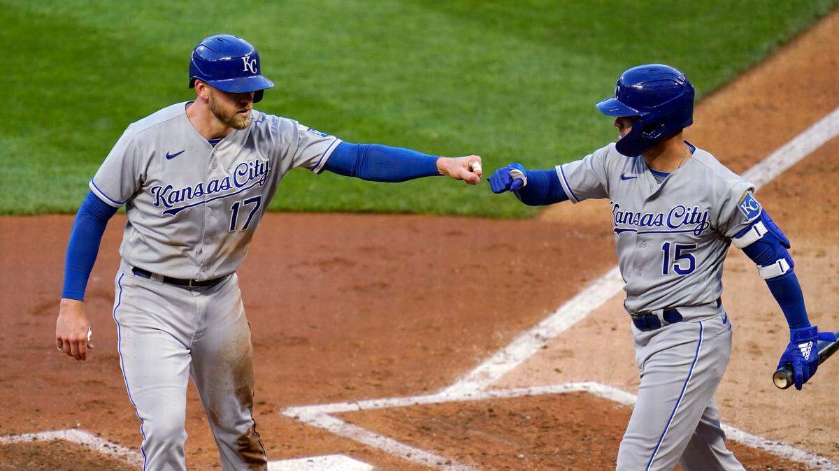 The Royals’ Hunter Dozier (left) gets a fist bump from Whit Merrifield after scoring on a double by Michael Taylor during the fifth inning on Friday, May 28, 2021, in Minneapolis.