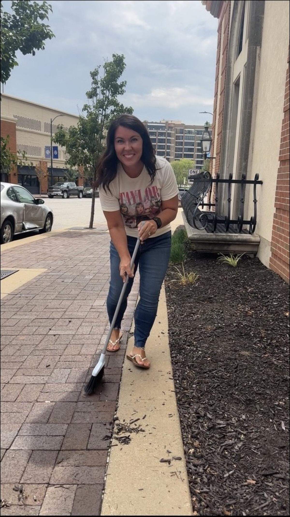Loan officer Melissa Hubbell swept sidewalks in her Taylor Swift T-shirt.