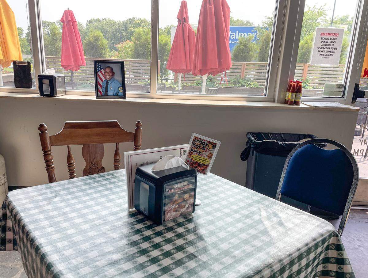 A photo of of Wyandotte County sheriff's deputy Elijah Ming is displayed near table 71 at Gus's Fried Chicken in Kansas City, Kansas. Ming, who was killed in the line of duty while responding to a call, was a regular at the restaurant.