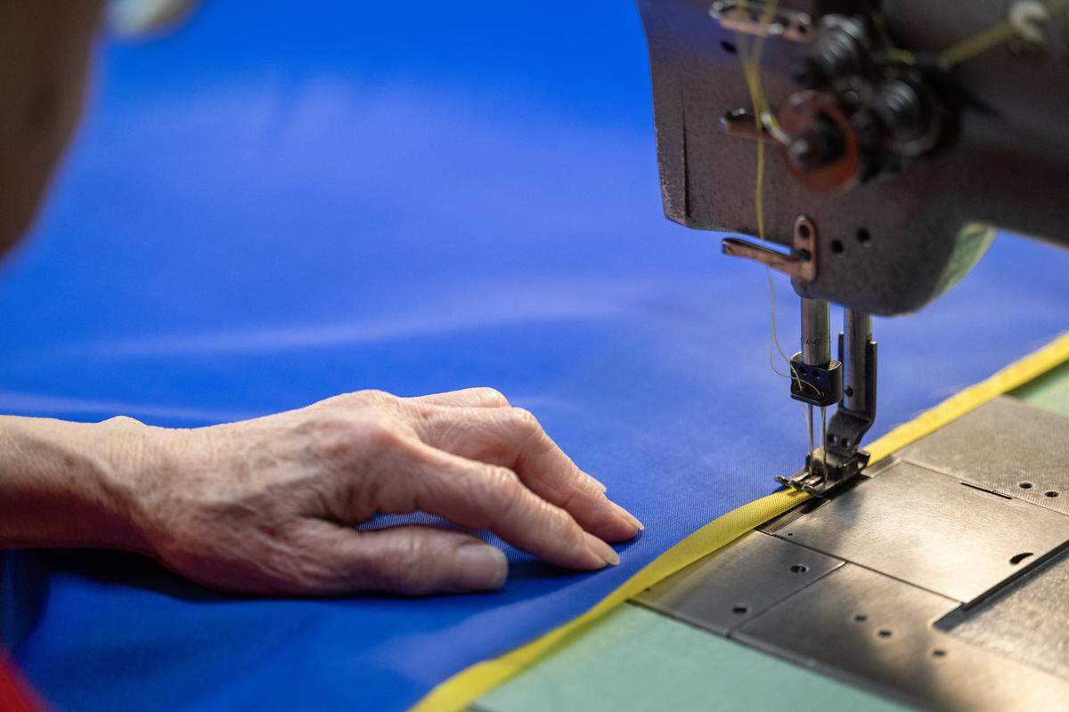 Using a vintage 1950s Singer sewing machine, seamstress Phuong-Thu Nguyen, 78, guides fabric beneath the double needles as she makes a flag of Curaçao at All Nations Flag Co. on Thursday, Jan. 8, 2026, in Kansas City. Curaçao is one of seven nations set to compete in the FIFA World Cup matches hosted in Kansas City this summer. All Nations Flag Co., is gearing up for the thousands of fans that will descend on Kansas City for the matches.