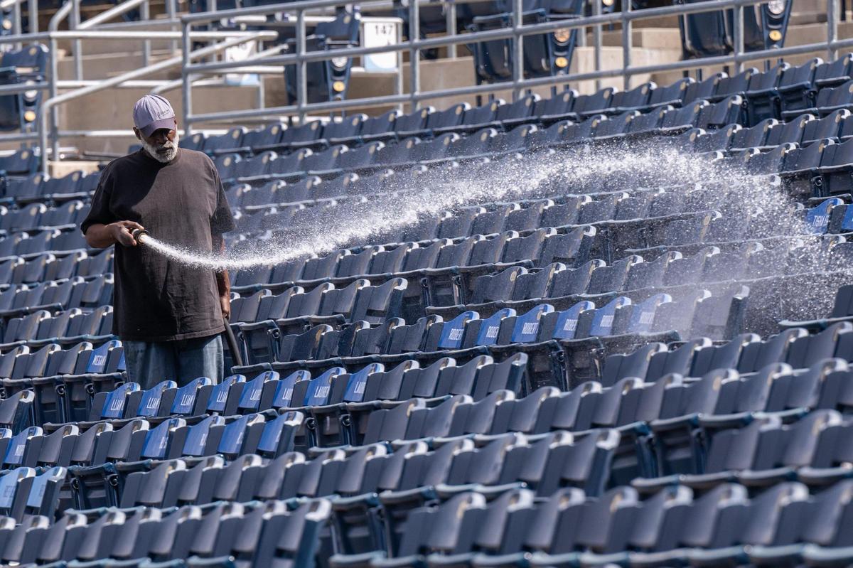 A temporary stadium crew worker sprays down seats at Kauffman Stadium on Tuesday, March 25, 2025. After sitting mostly vacant all winter, crews worked throughout the day to prepare for Opening Day for the Kansas City Royals.