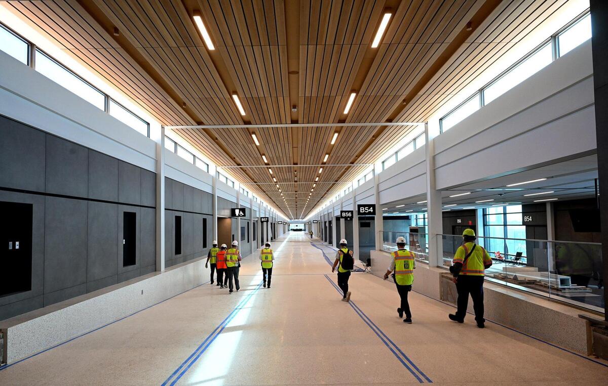 Construction on the new Kansas City International Airport continues and is about 90 percent complete. The airport is slated to open in March of 2023 and feature 39 gates. Hemlock planks line the ceiling inside much of the facility, including concourse B. The project will also include a 6,300-space parking structure along landside and airside improvements.