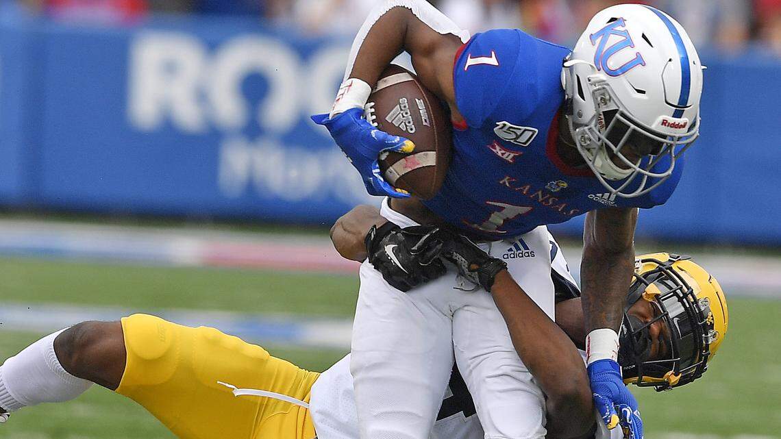 KUs Pooka Williams was brought down by West Virginia’s Hakeem Bailey after picking up yardage during the first half of the game on Saturday Sept. 21, 2019.