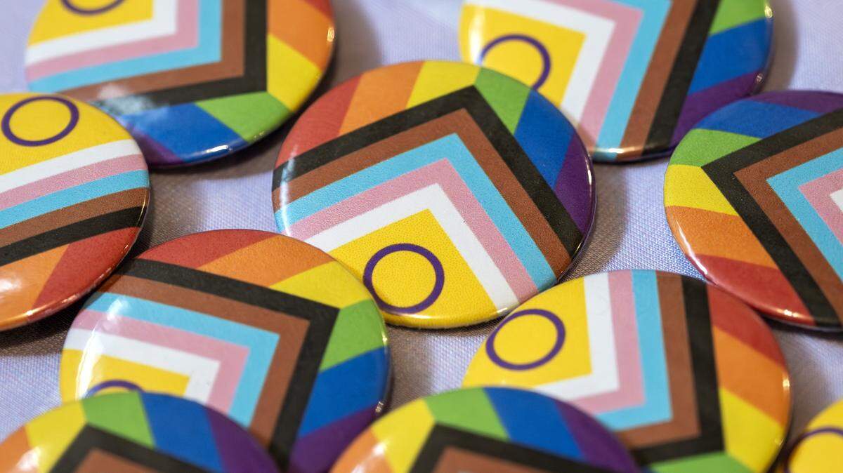 Buttons featuring LGBTQ+ pride flag colors are displayed on a table during a Trans Day of Remembrance event at Spirit of Hope MCC on Tuesday, March 31, 2026, in Kansas City.
