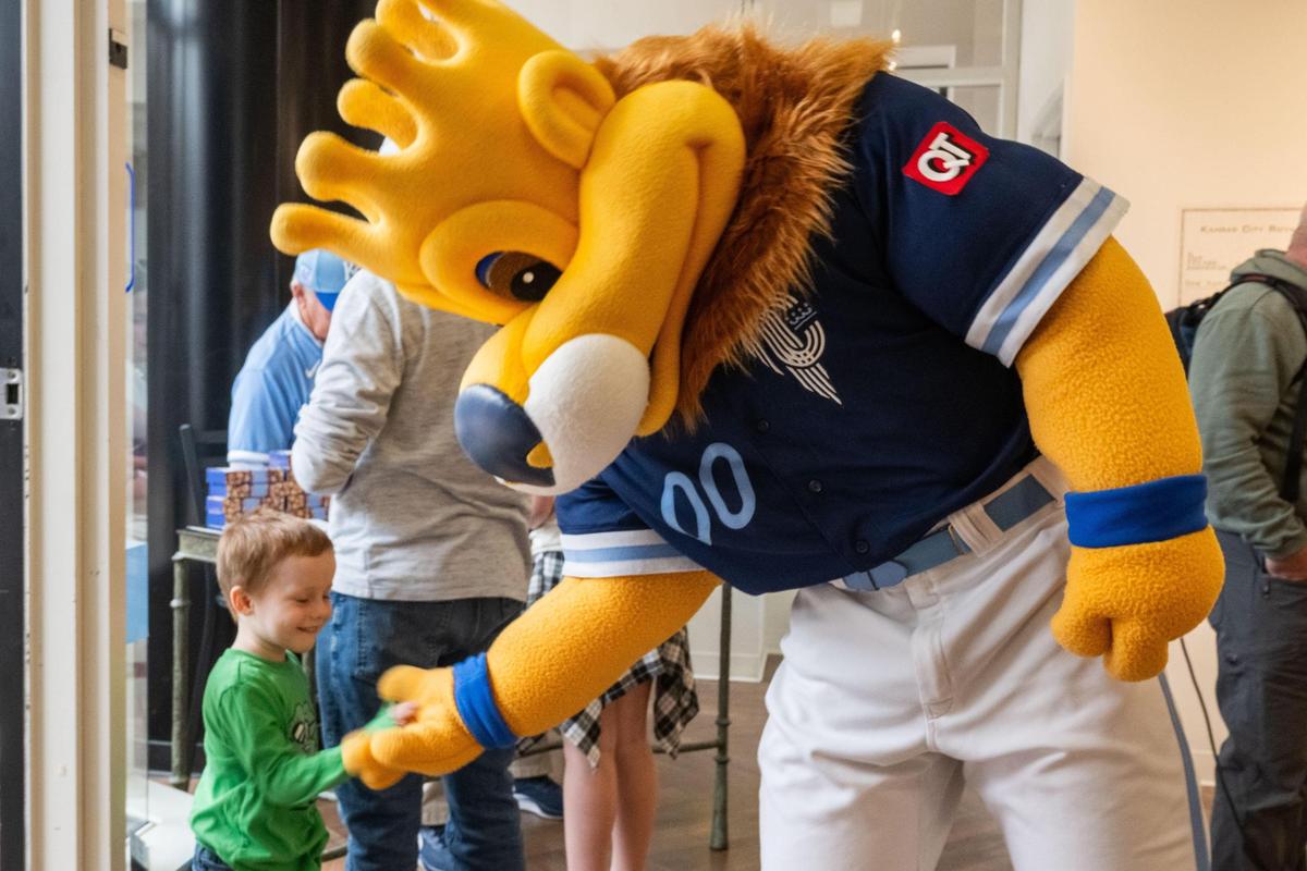 Kansas City Royals mascot Sluggerrr greets Oliver Killen at the Royals’ Crowning Achievements Exhibit at Commerce Bank in downtown Kansas City.
