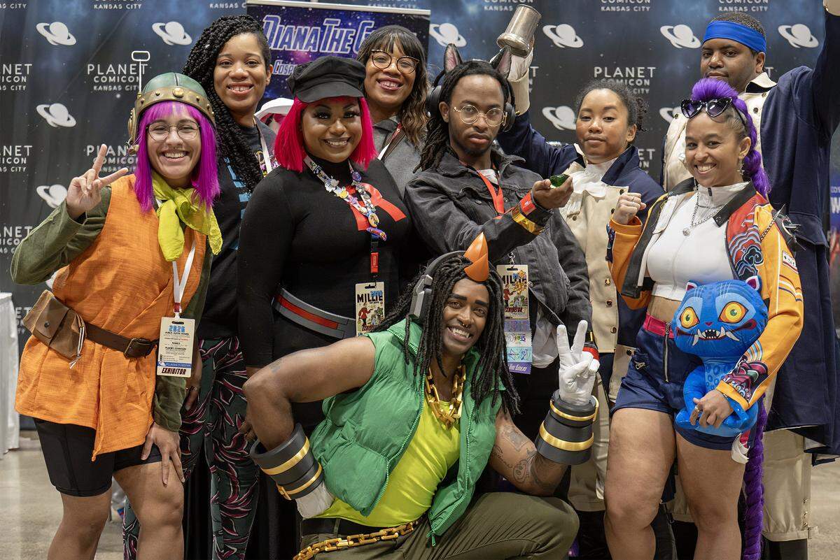 Fellow cosplayers gather around Diana Alexander, second from left, black cap, at her booth during Planet Comicon Kansas City at Bartle Hall on Sunday, March 29, 2026. A costume designer and highly regarded figure in the cosplay community, Alexander visited with the cosplayers during the final day festivities.
