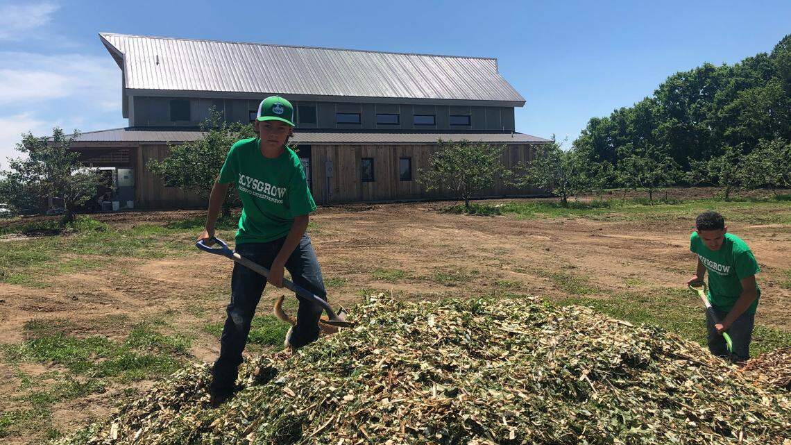 Olathe resident Kaleb Dohrman (left) shovels materials on the BoysGrow farm in south Kansas City.