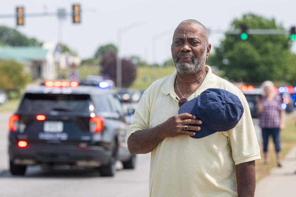 Glenn Haygood salutes the officers along State Avenue as police lead a funeral processional for slain KCKPD Officer Hunter Simoncic, on Wednesday, Sept. 3, 2025, in Kansas City, Kansas. Simoncic was killed Aug. 26 after being struck by a fleeing driver while deploying stop sticks.