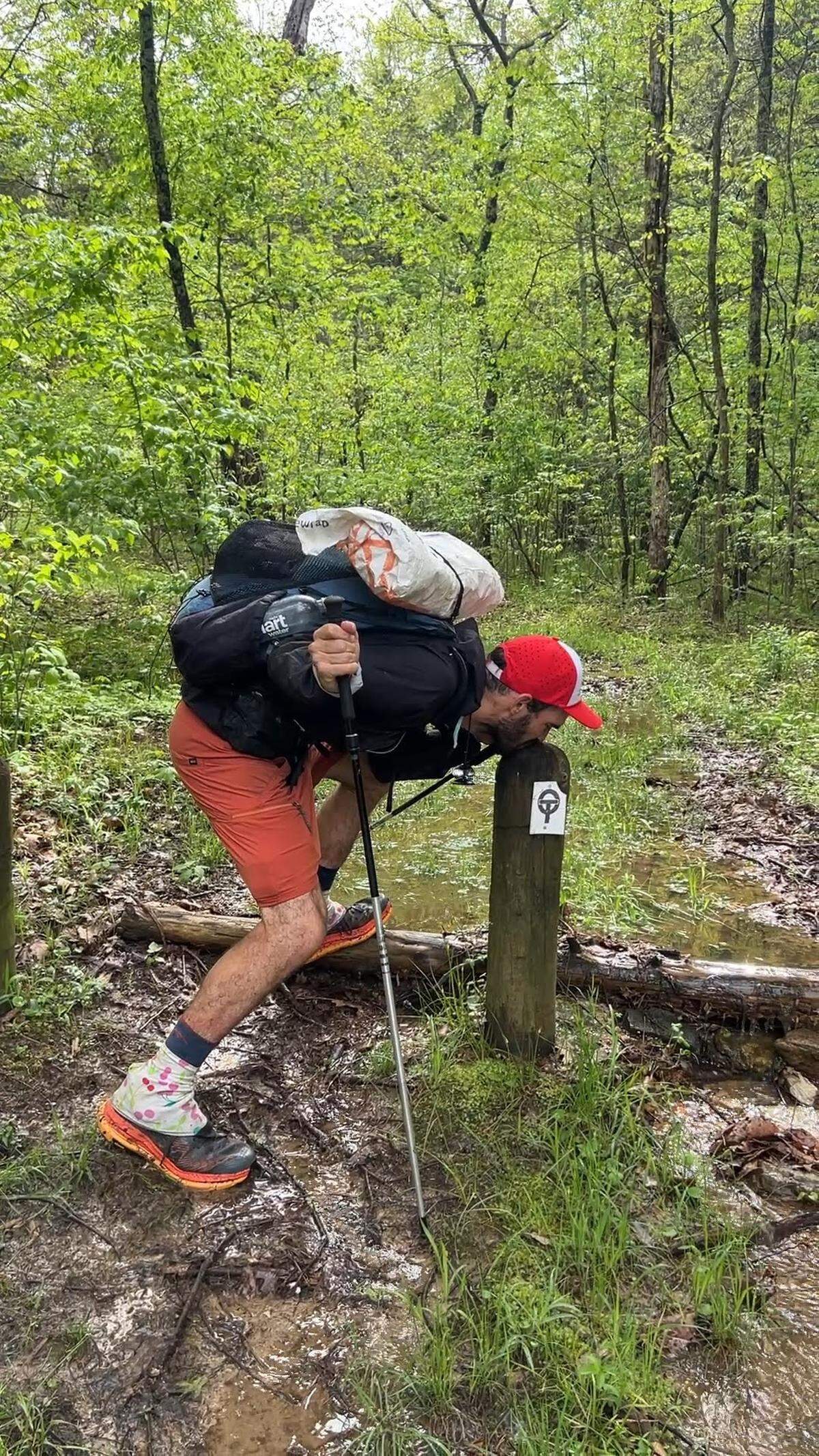 Beissinger kisses the trail marker as he completes his record-breaking hike.