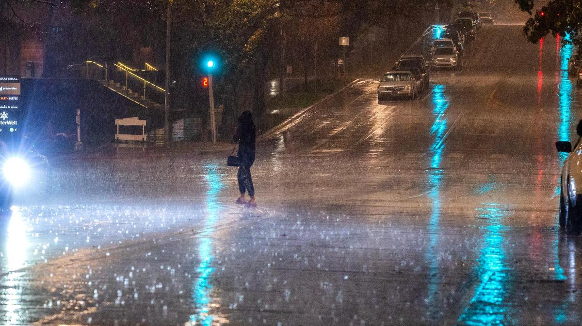 A resident walks through heavy rain on Wednesday night in Kansas City on Oct. 30, 2024.