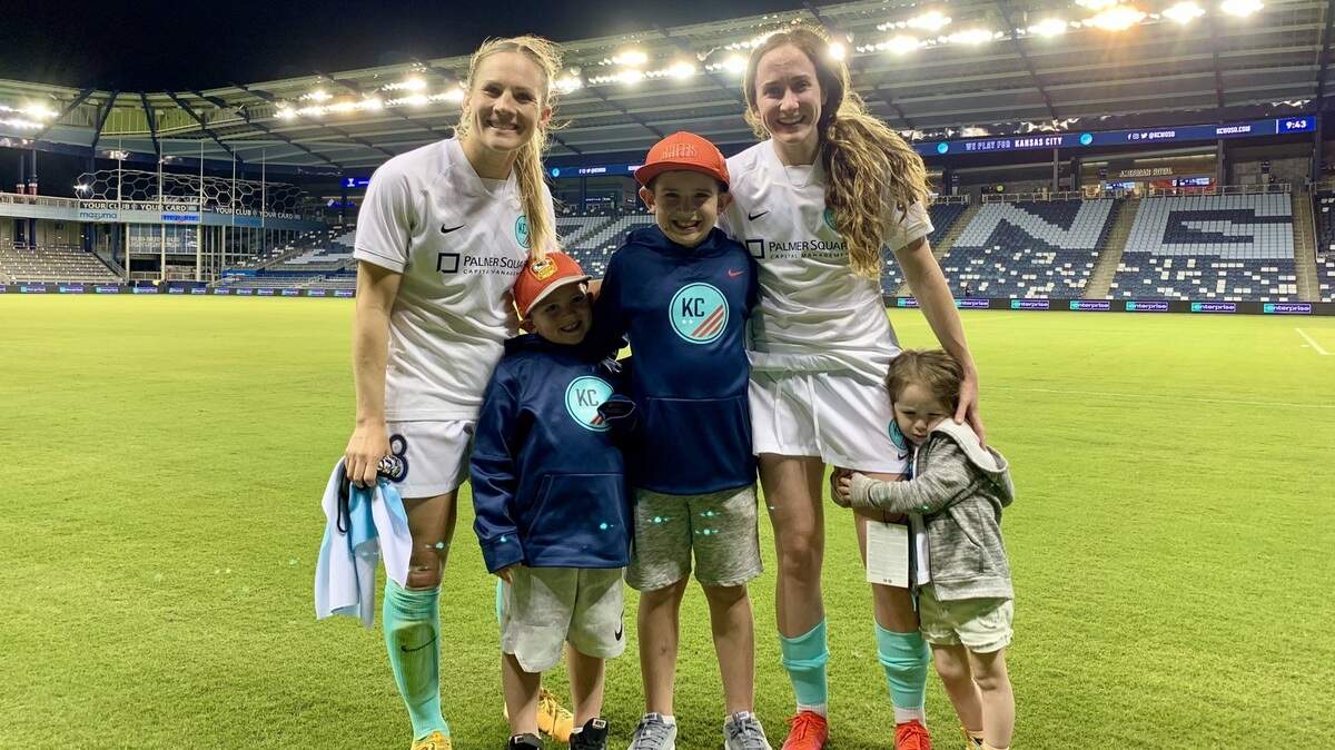KC NWSL moms Amy Rodriguez, left, and Michele Vasconcelos with their kids after the team’s opener at Children’s Mercy Park earlier this spring.