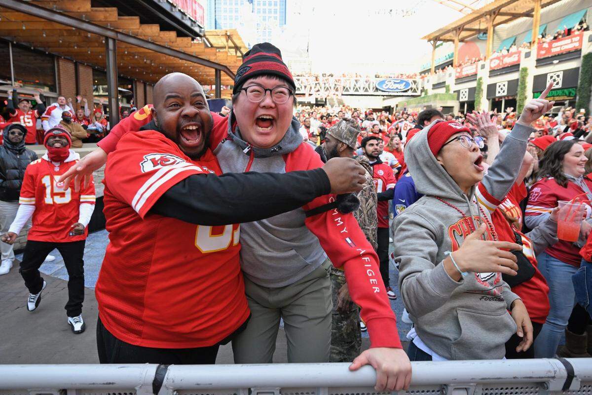 Chiefs fans from left,&nbsp;Jimmie Clark of East St. Louis, Andrew Kang of Kansas City and his brother, Joonyoung Yang, right, who flew in from South Korea Sunday for the Chiefs game, celebrate a touchdown at the Power & Light District during the AFC Championship Game on Sunday, Jan. 27, 2024.