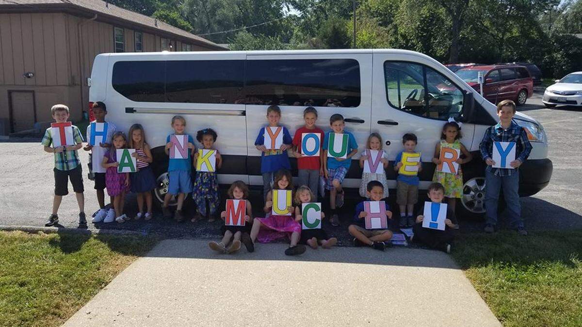 Children at Southview Christian Church in Grandview say “Thank you much!” with signs celebrating an anonymous gift of a new 15-passenger van a week after the church’s old van was stolen.