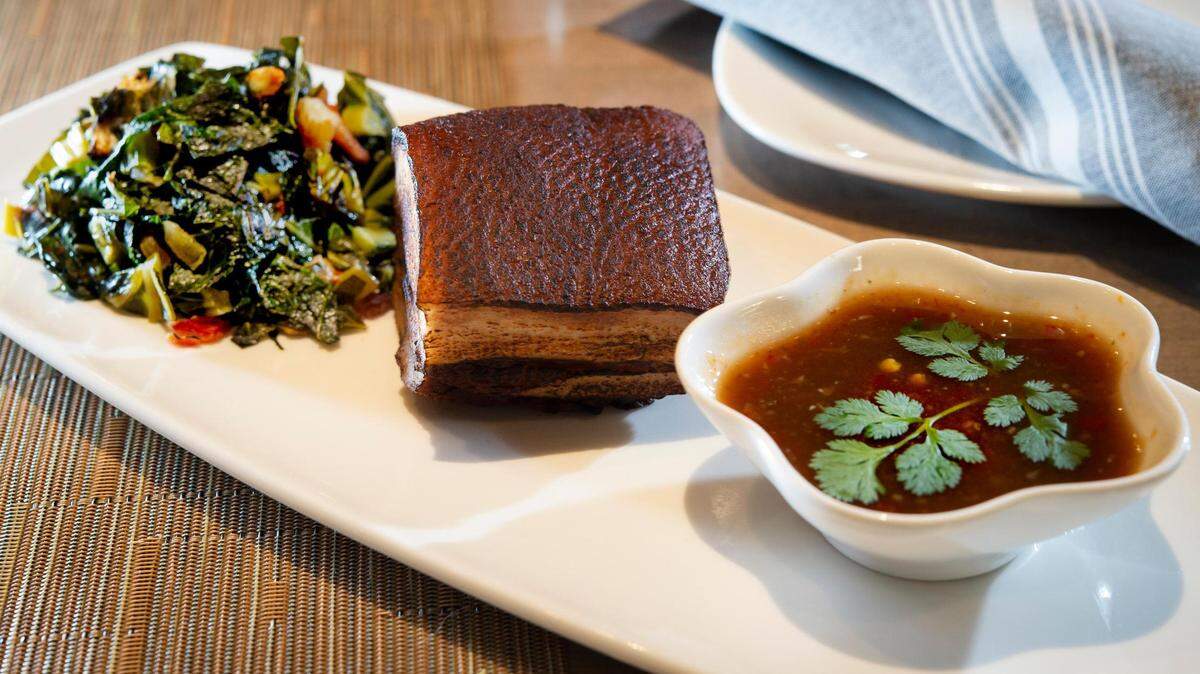 Seared pork belly and collard greens at Bamboo Penny’s at 5270 W. 116th Place in Leawood.