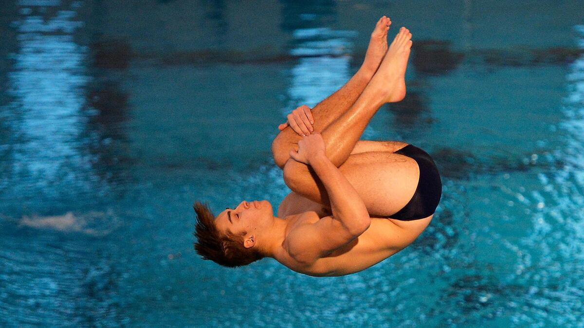 Olathe South sophomore Brice Faulkner tucks for one of his dives in the one-meter diving competition Friday, February 19, 2021, at the 6A Kansas Boys State Swimming and Diving Championships in Lenexa.