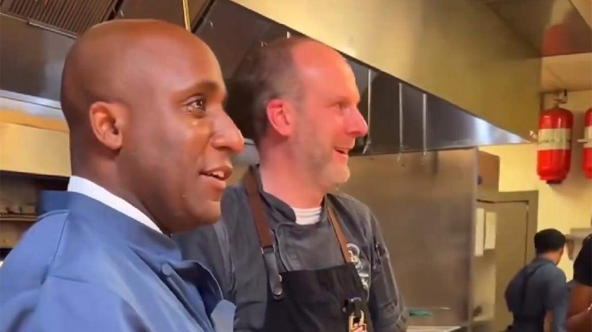 Quinton Lucas visits Q39 barbecue restaurant, which is featuring the Mayor "Q" 39, a smoked brisket and pimento grilled cheese sandwich in honor of the mayor's 39th birthday. Behind him is chef Philip Thompson.