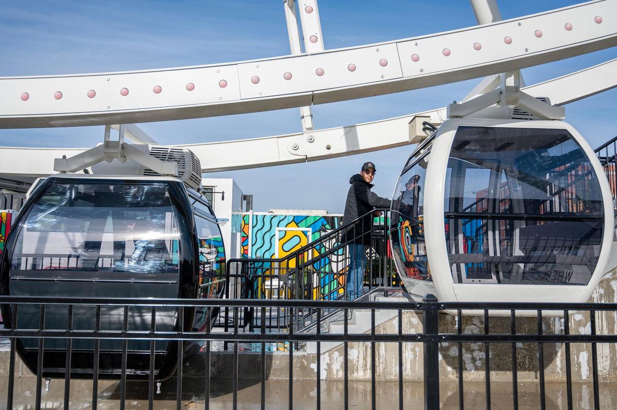 Dominic Arnone, wheel operator, whips down hand reels near the KC Wheel at Pennway Point district on Wednesday, Dec. 13, 2023, in Kansas City.
