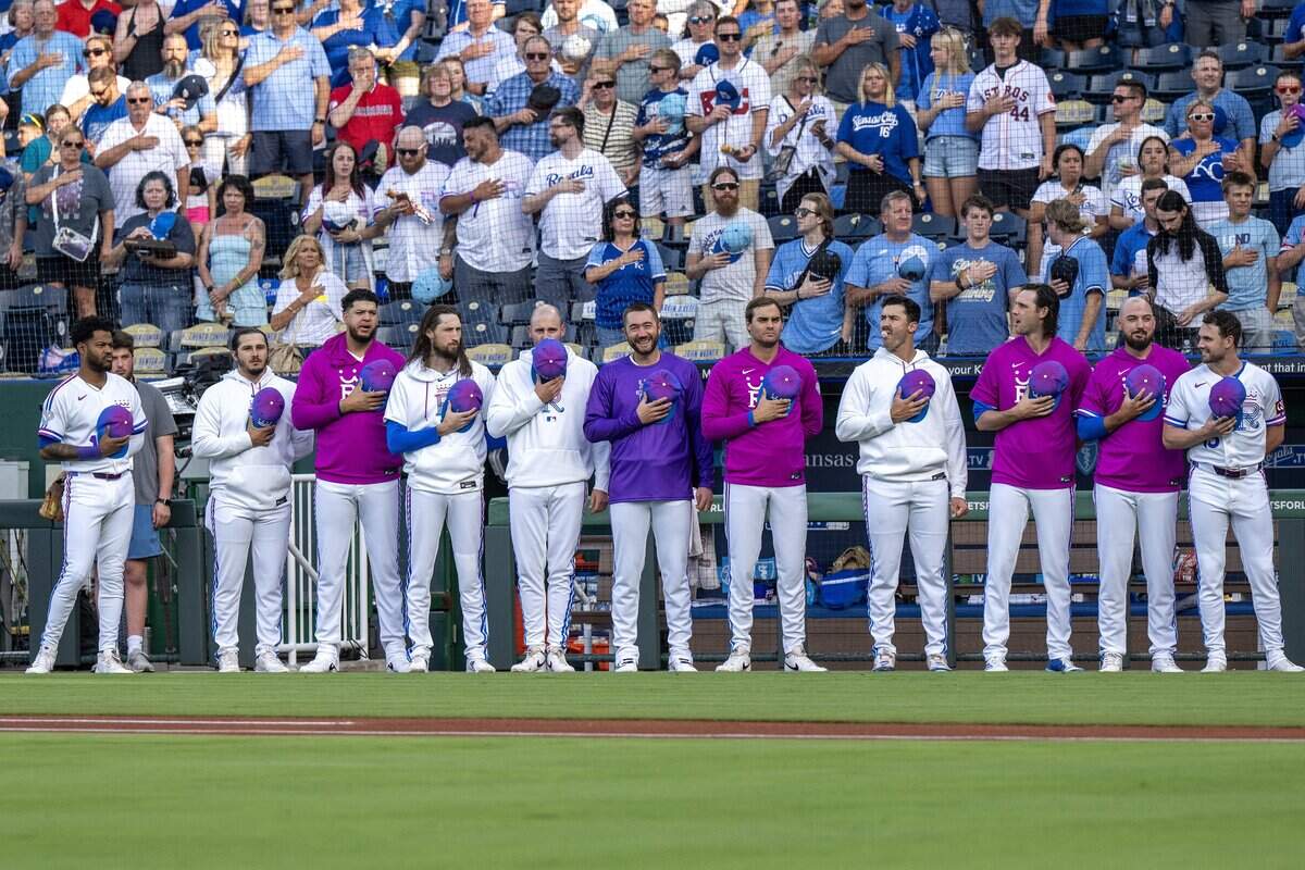 Kansas City Royals players stand for the national anthem wearing the team's new "Forever Fountains" City Connect uniforms before a game against the Houston Astros on Friday, June 12, 2026, at Kauffman Stadium in Kansas City.