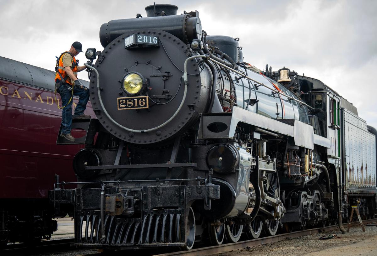 Ben Cummings, a locomotive engineer from Lethbridge, Alberta, Canada, hops off the Empress 2816, a 1930 steam locomotive while doing some maintenance on Thursday, May 16, 2024, at the CPKC rail yard in Kansas City. Canadian Pacific Kansas City (CPKC) is celebrating its’ anniversary, the merger with KC Southern, with the Final Spike Anniversary Steam Tour, which makes a stop at Union Station on Saturday, May 18, 2024.