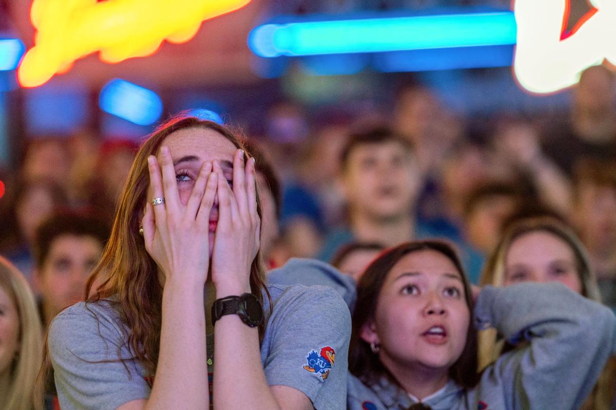 Kansas Jayhawks fan, Lauren DeWitt, watches as the Jayhawks tie the North Carolina Tar Heels for the NCAA National Championship at Power and Light District on Monday, April 4, 2022.