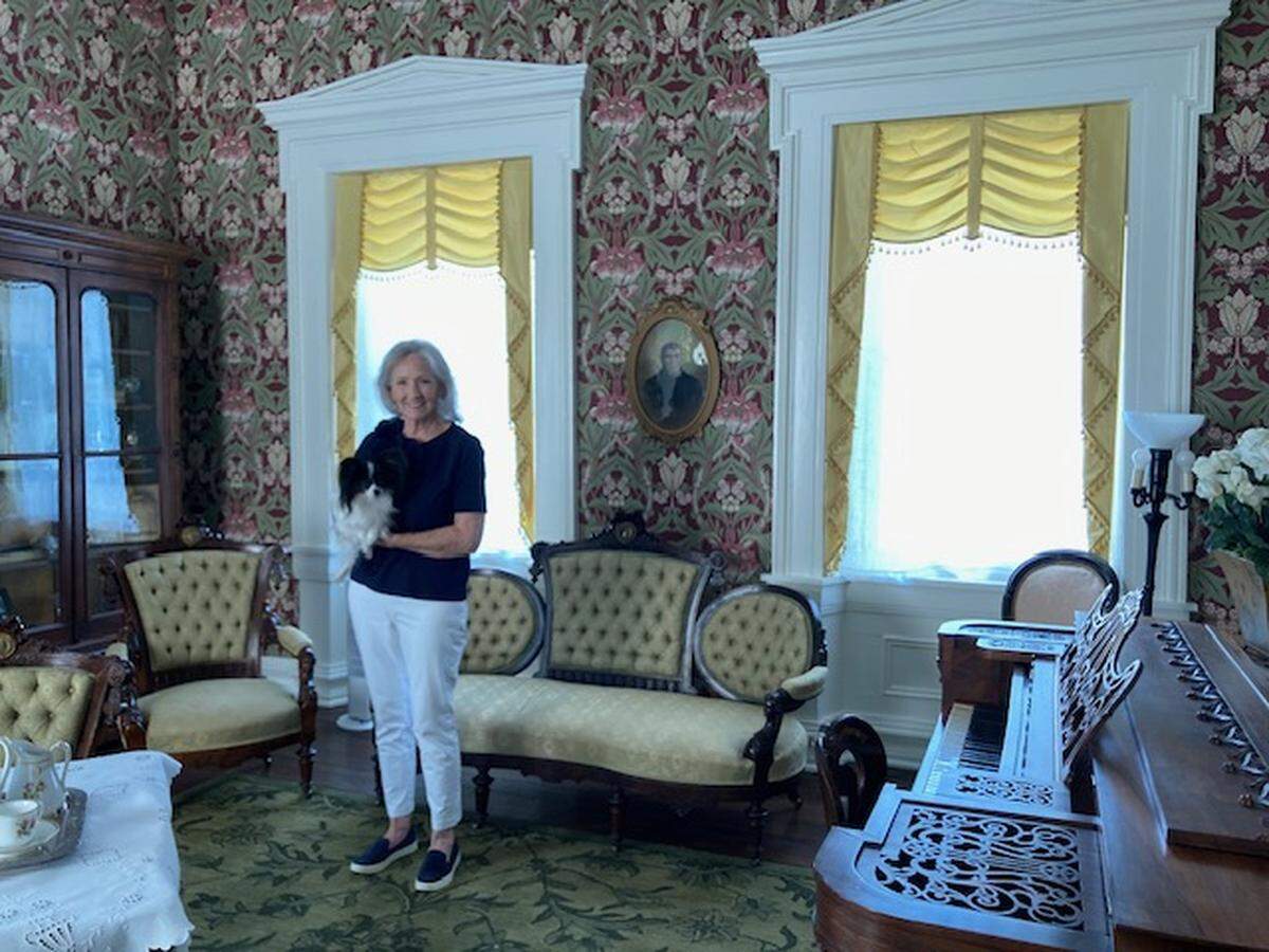 Westport Historical Society President Marty Wiedenmann Jarvis, with her dog Papillon, in the parlor of the recently renovated 1855 Harris-Kearney Historical House Museum, 4000 Baltimore Ave.
