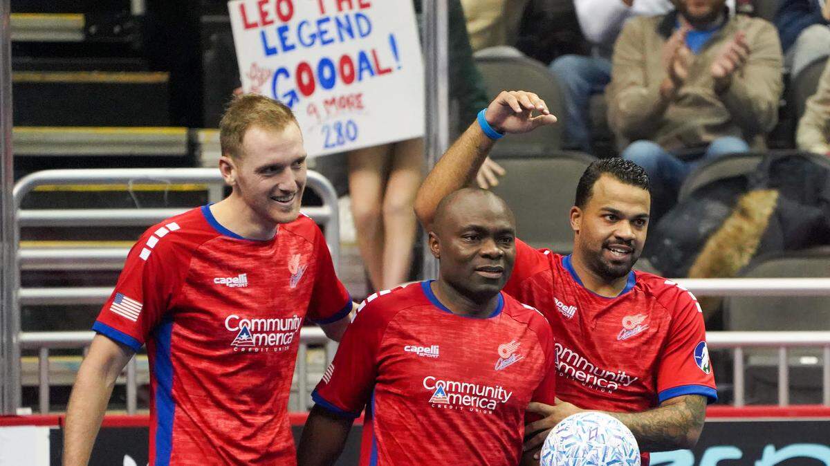 Fans hold up a sign behind Comets player/coach Leo Gibson, center, during the club’s 9-2 victory over the Tacoma Stars on Saturday at the T-Mobile Center in downtown Kansas City. Gibson had four goals in the match; Kevin Ellis, right, scored a goal, as well.