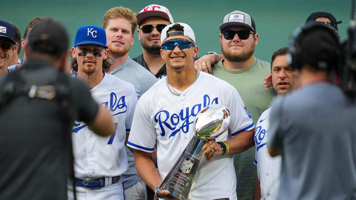 Kansas City Chiefs quarterback Patrick Mahomes poses for a photo with teammates prior to a game between the Cincinnati Reds and the Kansas City Royals at Kauffman Stadium on June 12, 2023.