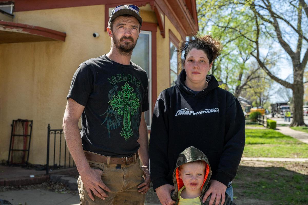 David King, left, his wife Amanda Phifer, and their 4-year-old son Colton stand outside their home Tuesday in Lexington, Missouri.