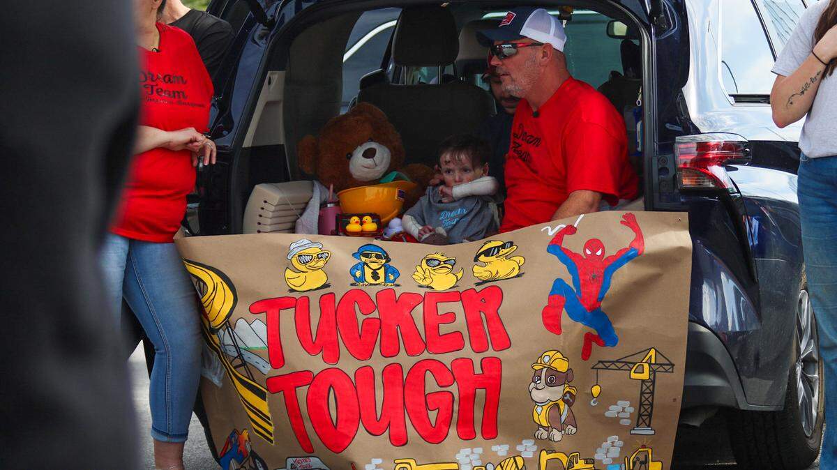 Tucker Langford, 3, sits with family in the back of an SUV on Saturday, Oct. 11, 2025. A parade honoring him while he battles a terminal illness drew hundreds of participants.
