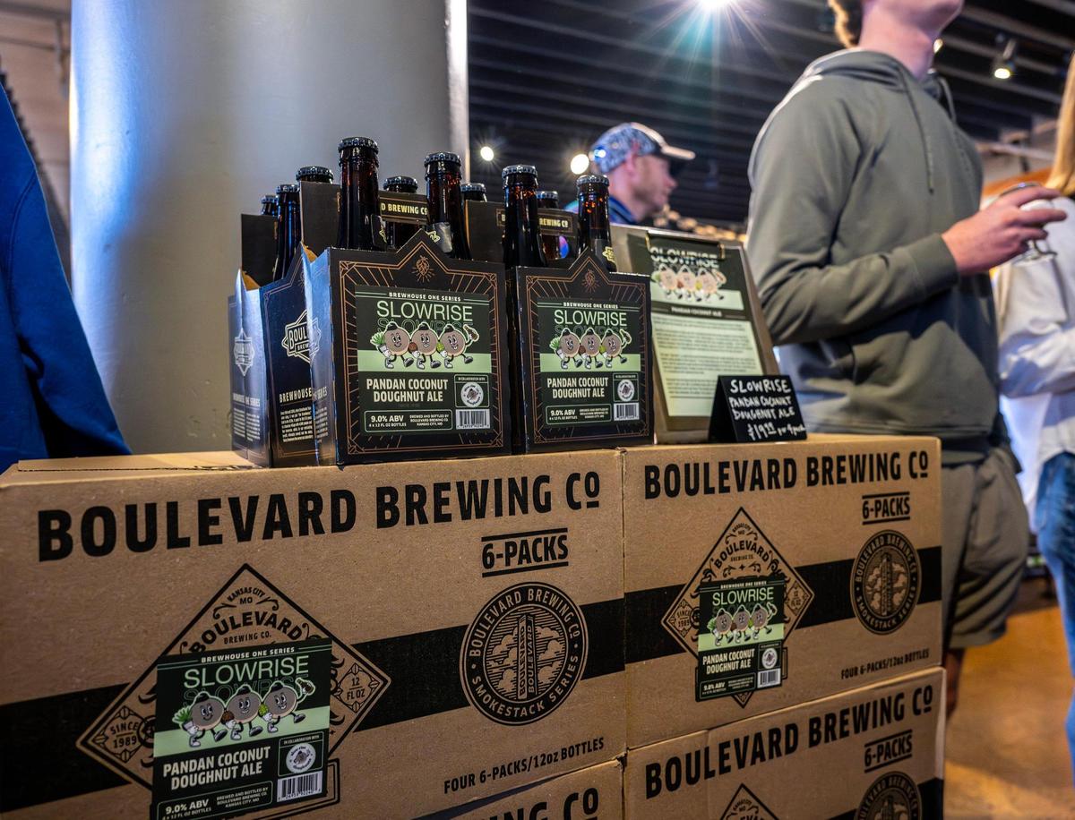 Cases of Pandan Coconut Doughnut Ale are displayed as people wait in line for the Slow Rise Doughnuts pop-up during the Pandan Coconut Doughnut Ale release party at Boulevard Brewing Tours and Recreation Center on Sunday, March 9, 2025, in Kansas City.