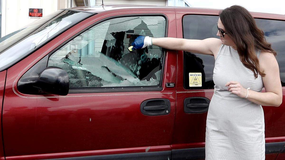 Amber Rollins, director of KidsAndCars.org, demonstrates how to safely break a window using a device, the Resqme emergency window breaker and seat belt cutter, at 169 Auto Parts in Spring Hill on June 25, 2018. A Kansas law went into effect legally protecting Good Samaritans who break a window to rescue a person or animal.