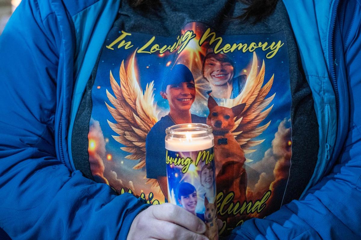 Emily Williams, a coworker of Katherine Bjorklund, wears a tribute shirt and holds a candle in honor of Katherine during a vigil at Riverside Car Wash on Thursday, March 6, 2025, in Kansas City.