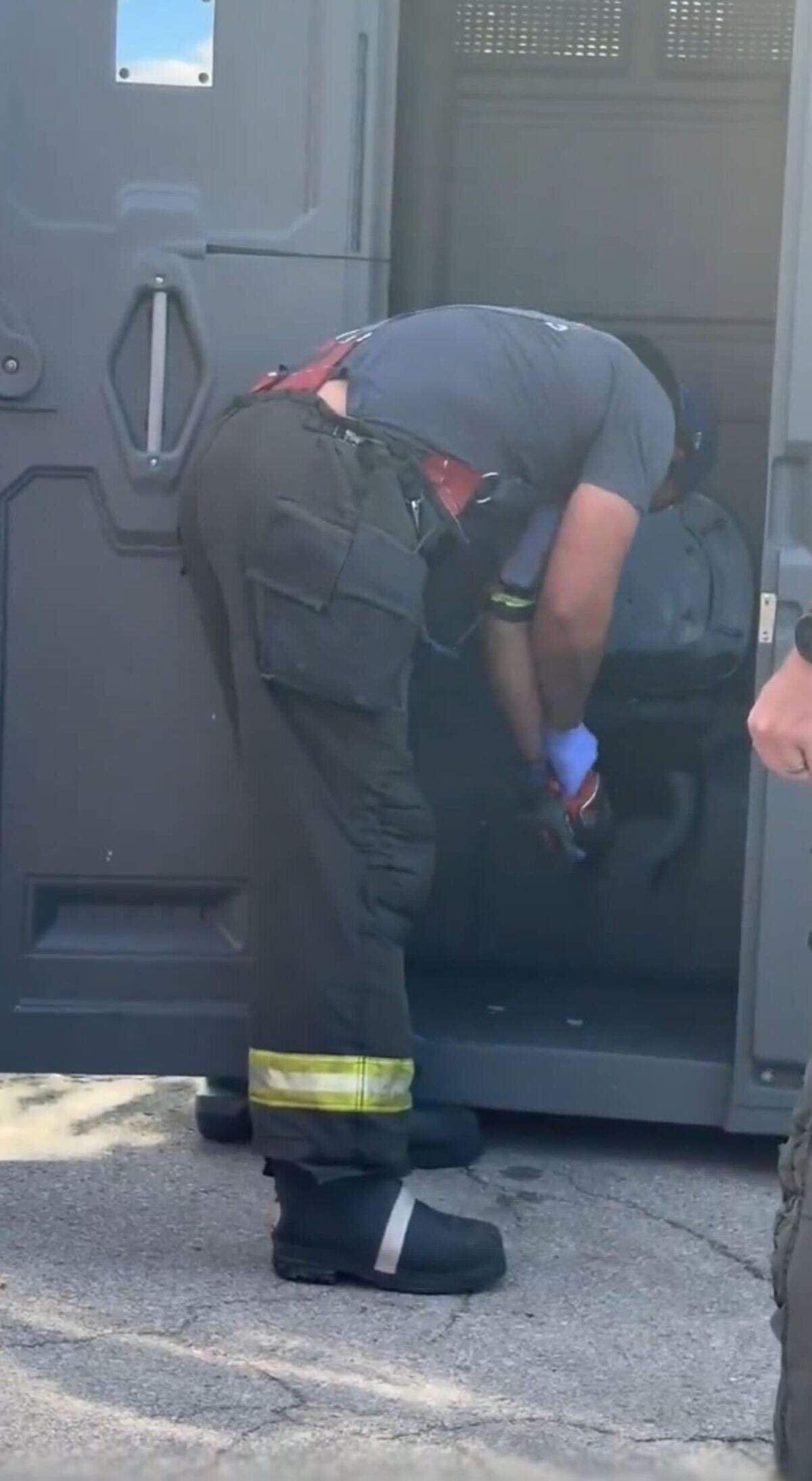 A screenshot from the viral video of a Kansas City firefighter helping a man get out of a porta potty on July 14, 2026, in Kansas City, Missouri.