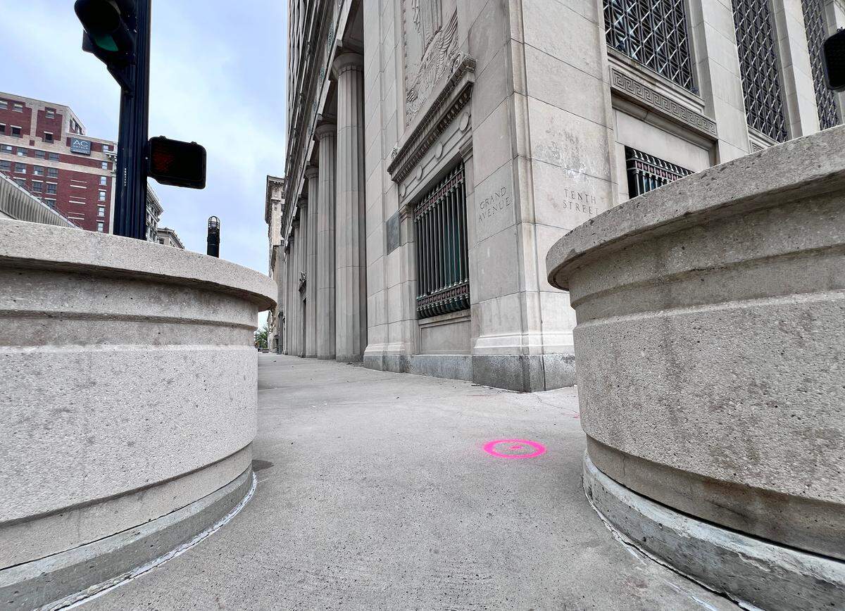 The historic Federal Reserve building at 925 Grand shows crumbling details and weathered stonework after sitting empty for over a decade, following an abandoned redevelopment project.