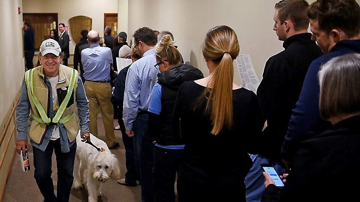 The early bird gets the worm as they say, and for Gordon Kelley that meant getting to the voting poll before dawn, even if he did have to wake up his companion, Linus. He was on his way out of the Country Club Church, while a long line of voters had formed.