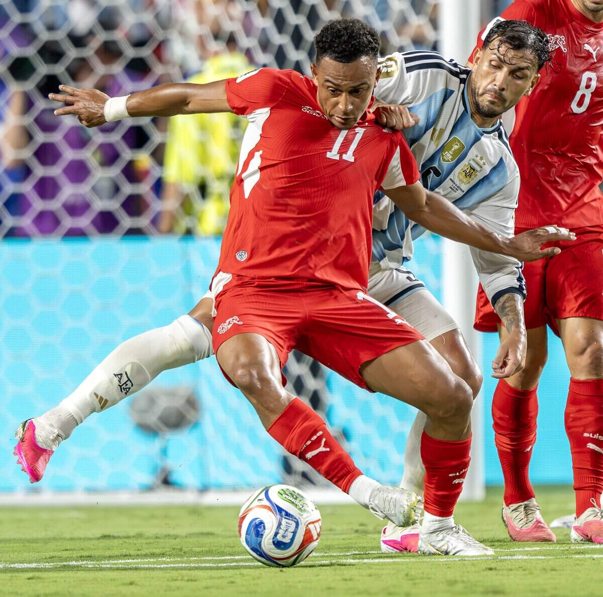 Switzerland forward Dan Ndoye (11) shields the ball from Argentina midfielder Leandro Paredes (5) during the second half of the FIFA World Cup quarterfinal match at Kansas City (Arrowhead) on Saturday, July 11, 2026.