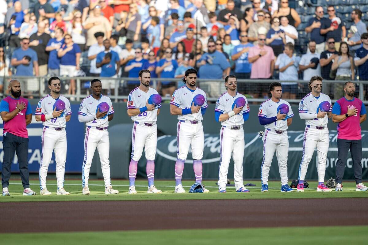Kansas City Royals players stand for the national anthem wearing the team's new "Forever Fountains" City Connect uniforms before a game against the Houston Astros on Friday, June 12, 2026, at Kauffman Stadium in Kansas City.