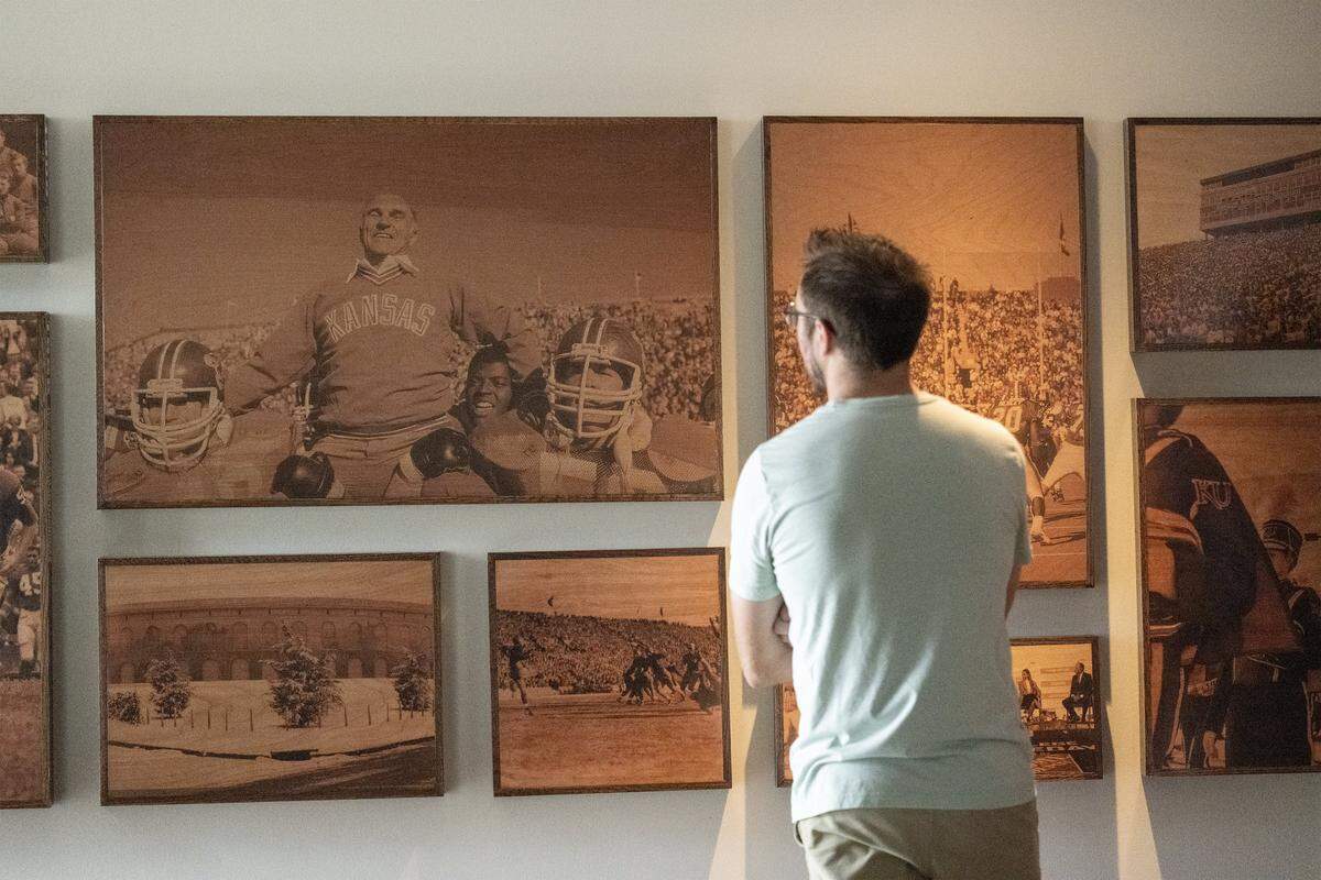 A guest views a display of vintage photos at the new David Booth Kansas Memorial Stadium on Tuesday, Aug. 19, 2025, at the University of Kansas in Lawrence.  