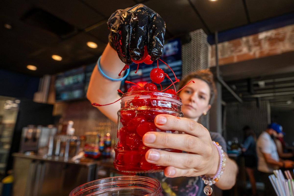 Bartender Rachel Bateman preps cherries at Cosmo Burger’s soft opening in the Crossroads.