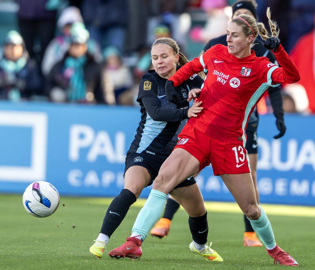 Gotham FC midfielder Josefine Hasbo, left, battles KC Current forward Haley Hopkins for the ball during an NWSL quarterfinal playoff match at CPKC Stadium in Kansas City on Sunday, Nov. 9, 2025.