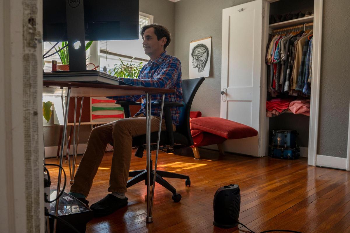 John Vasquez works beside a space heater inside his office at his home in Kansas City on Wednesday, March 16, 2022. Vasquez is a Spire customer who has been struggling with paying his heating bills this winter.