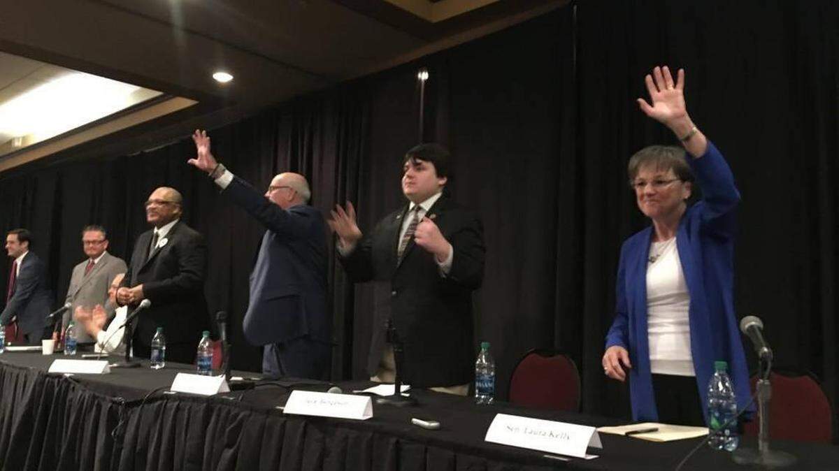 Kansas Democratic candidates for governor wave at the end of a forum Saturday. The state party is experiencing its first contested primary for governor in decades.