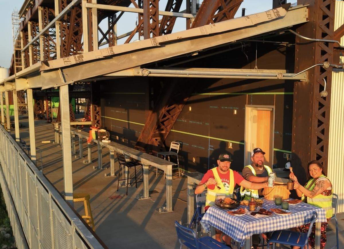 Andrew Miller (left) Bradley Gillmore and Brittany Gillmore dine on the Rock Island Bridge ahead of their concept’s opening.