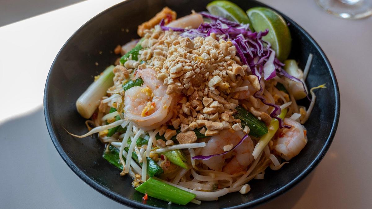 Lulu’s Thai Noodle Shop serves pad thai with shrimp, scallions, cashews, purple cabbage and limes.