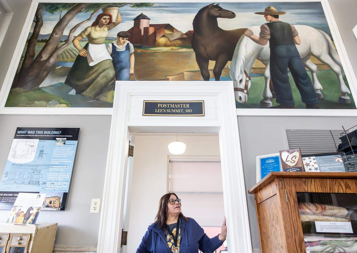 Susan Kerley, a volunteer docent with the Lee’s Summit History Museum, stands underneath Ted Gilien’s “Pastoral,” a mural that was installed in 1940.
