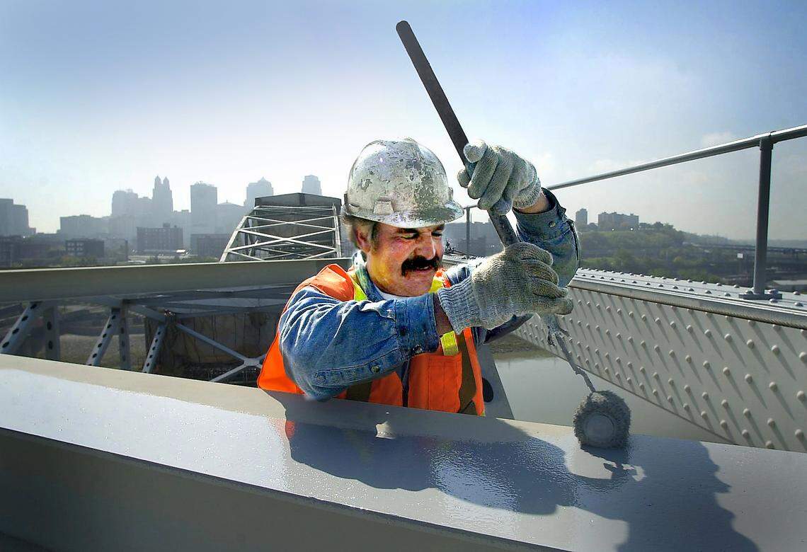 Worker Gary Tichenor stands atop the Buck O’Neil Bridge while adding a new coat of paint.